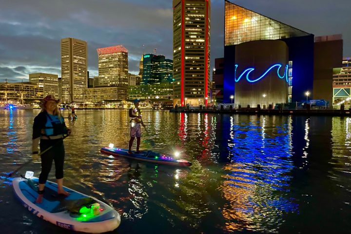 a group of people standing next to a body of water