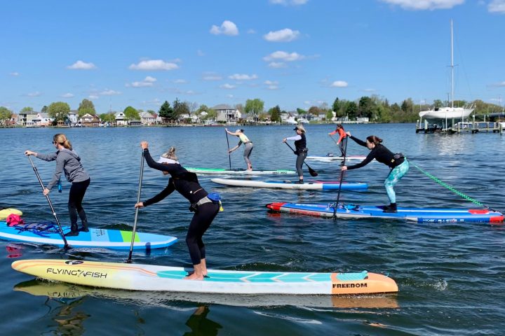a group of people riding on the back of a boat in the water