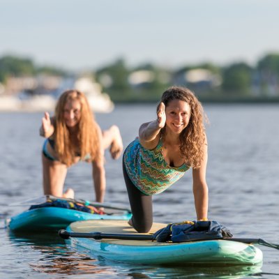 2 girls doing paddle board lesson