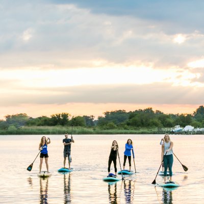 Group of people doing stand up paddle board tour