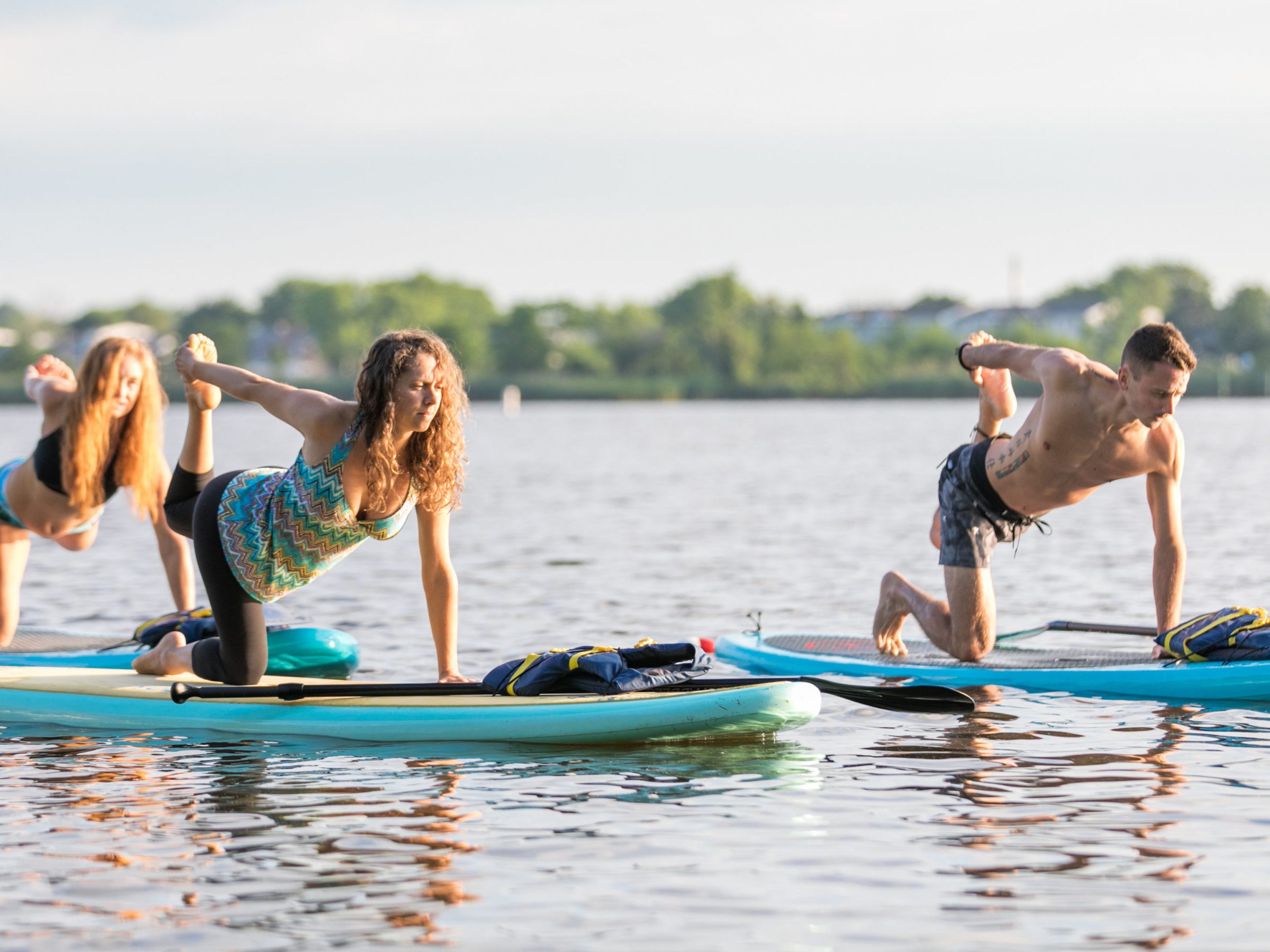 3 people doing paddle board training