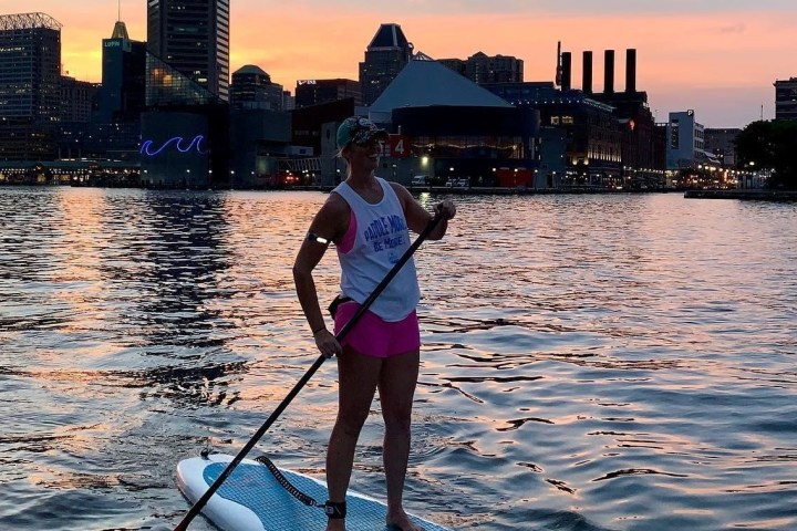 a woman standing next to a body of water