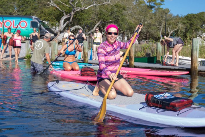 a group of people riding on the back of a boat in the water