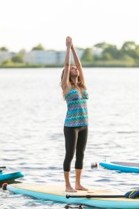 a little girl standing next to a body of water