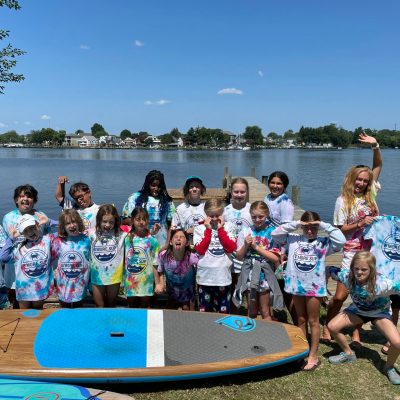 a group of people standing next to a body of water