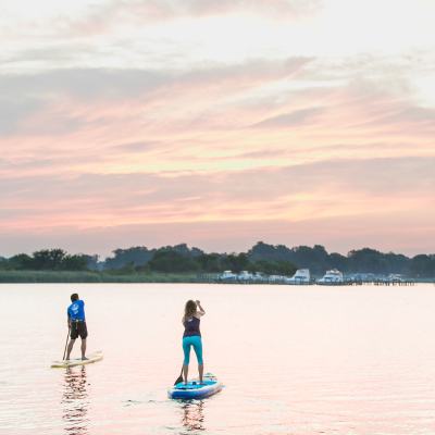 a group of people standing next to a body of water