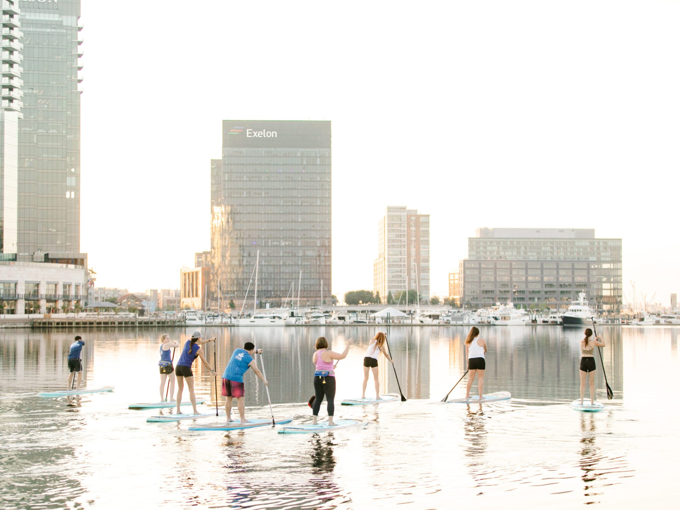 a group of people in a body of water with buildings in the background