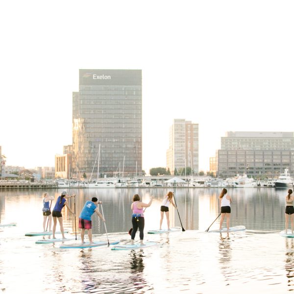 a group of people in a body of water with buildings in the background