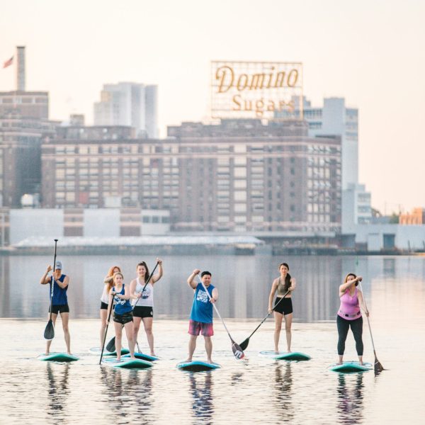 a group of people standing next to a body of water