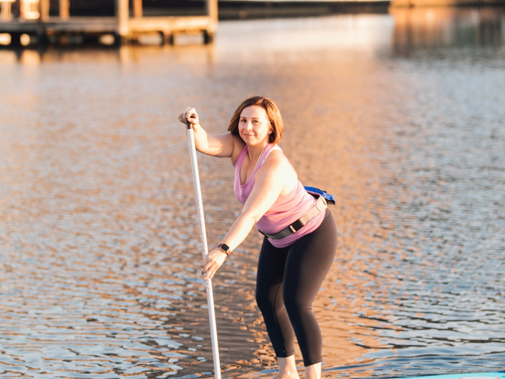 a little girl standing next to a body of water