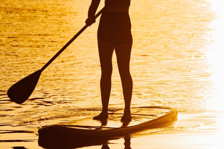 a person standing next to a body of water