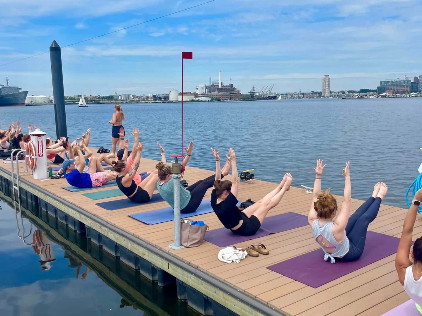 a group of people sitting on a dock next to a body of water